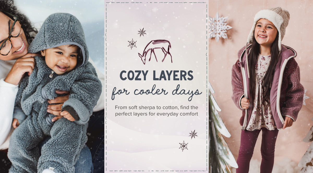 A promotional collage for cozy layered clothing, featuring a baby in a gray hooded sherpa outfit on the left, a child in a mauve and white zip jacket on the right, and a central text panel reading 'Cozy Layers for cooler days' with a small deer illustration.
