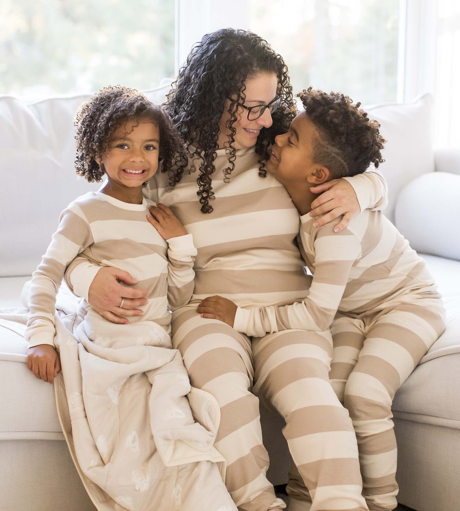 Striped oat organic cotton pajama sets on three family members, long sleeves and pants