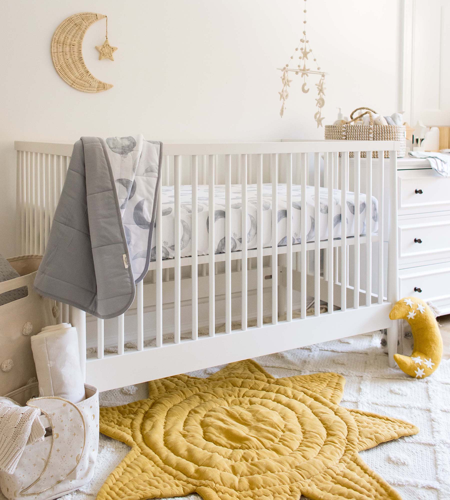 Fitted crib sheet on crib mattress with moon-themed pattern