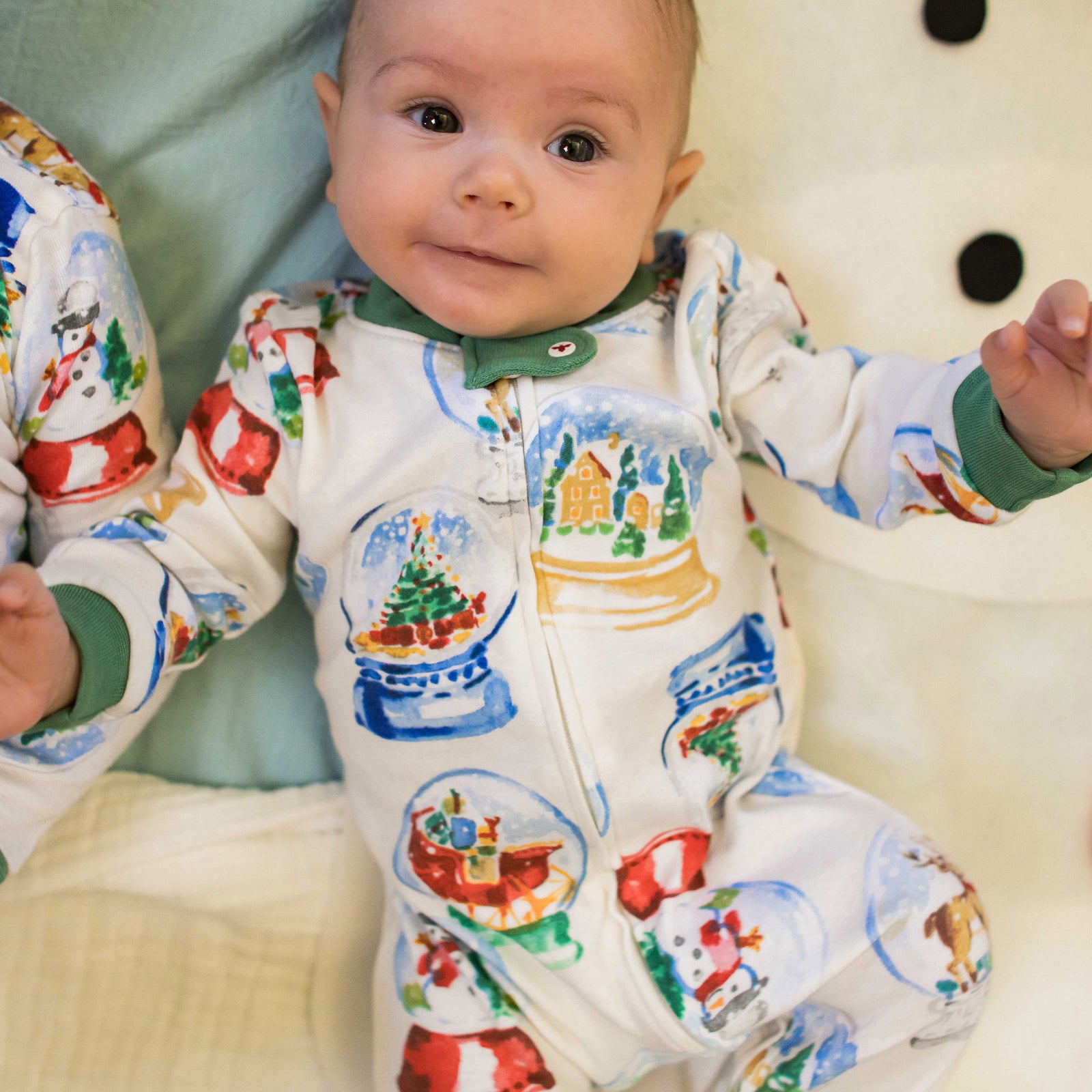 Footed organic cotton baby sleeper with colorful snowglobe animal prints and green cuffs - View 2