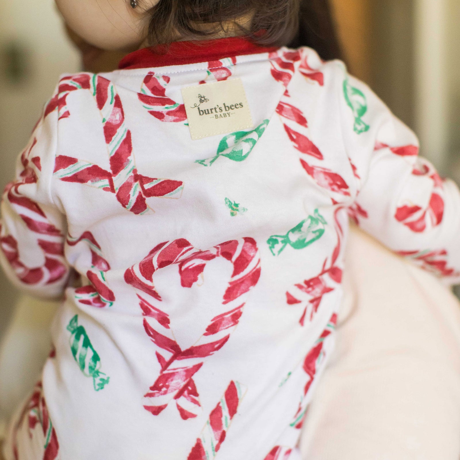 Organic cotton footed sleeper in white with red candy cane print and green accents, snaps - View 2