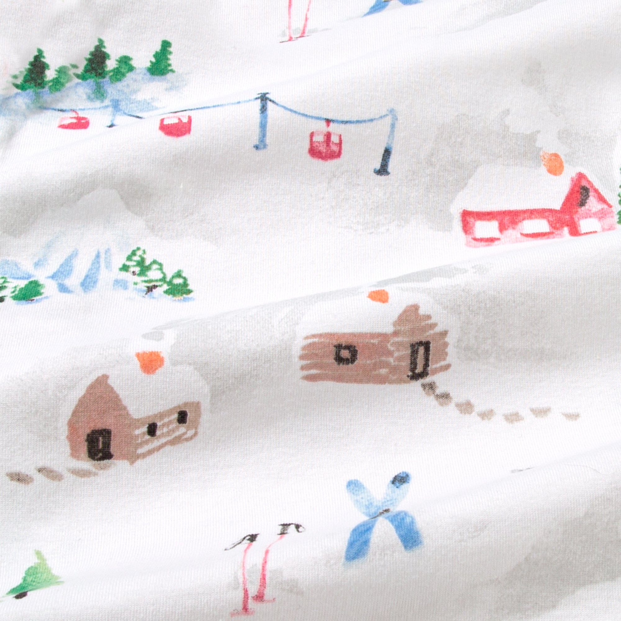 Close-up of white cotton fabric with colorful ski-slope holiday scene pattern