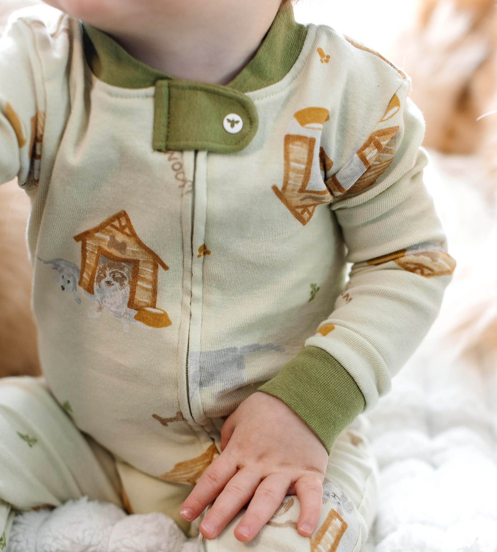 Close up on one-piece baby pajamas with dog house print pajamas from Burt's Bees Baby