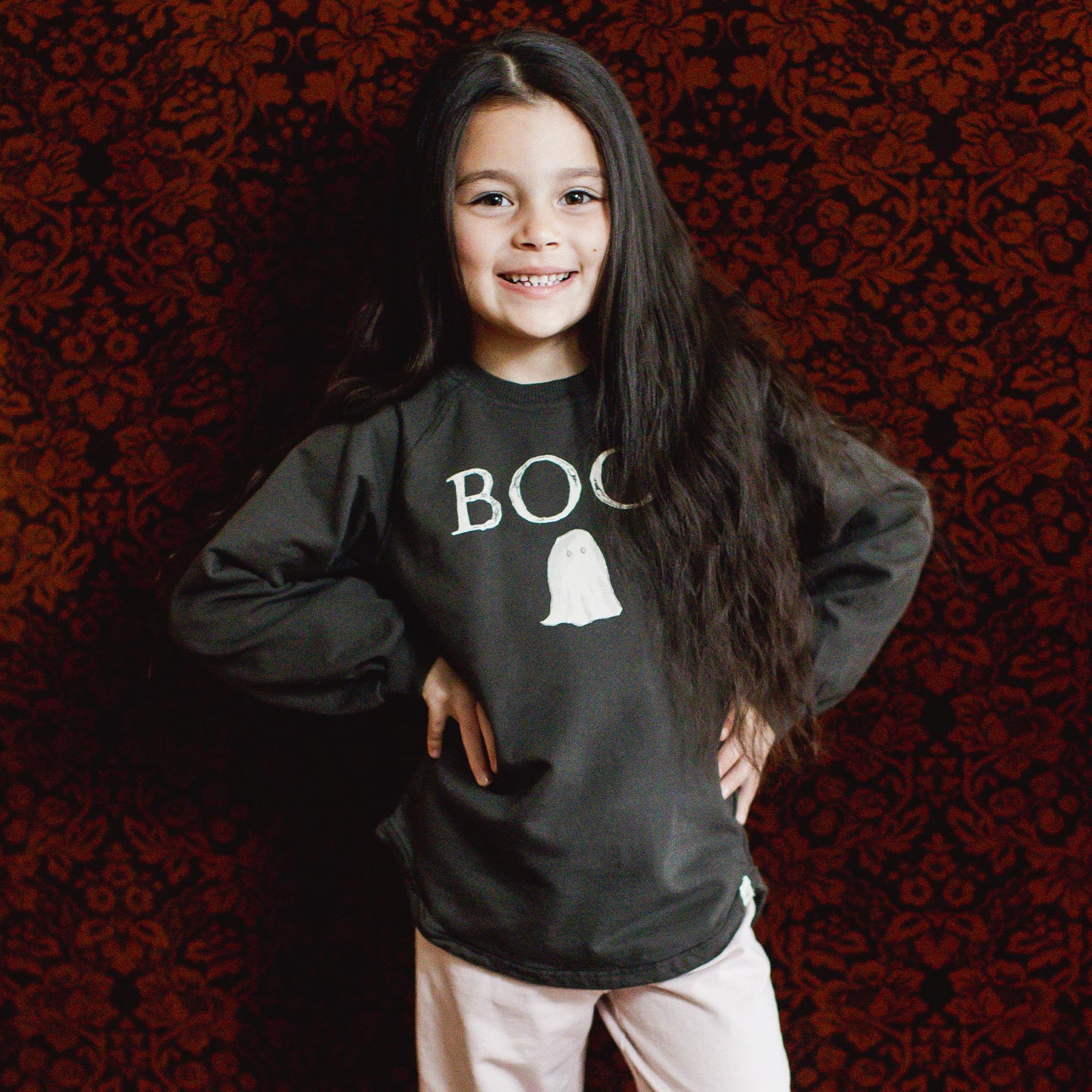 Child wearing dark organic cotton sweatshirt with BOO ghost graphic on the front - View 2